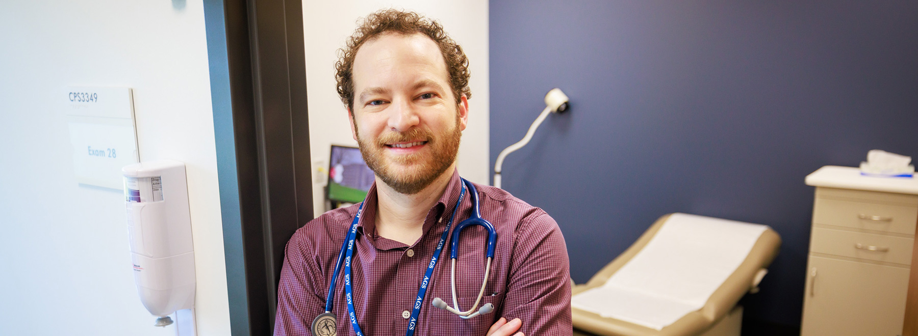 A doctor standing in the doorway of an exam room.